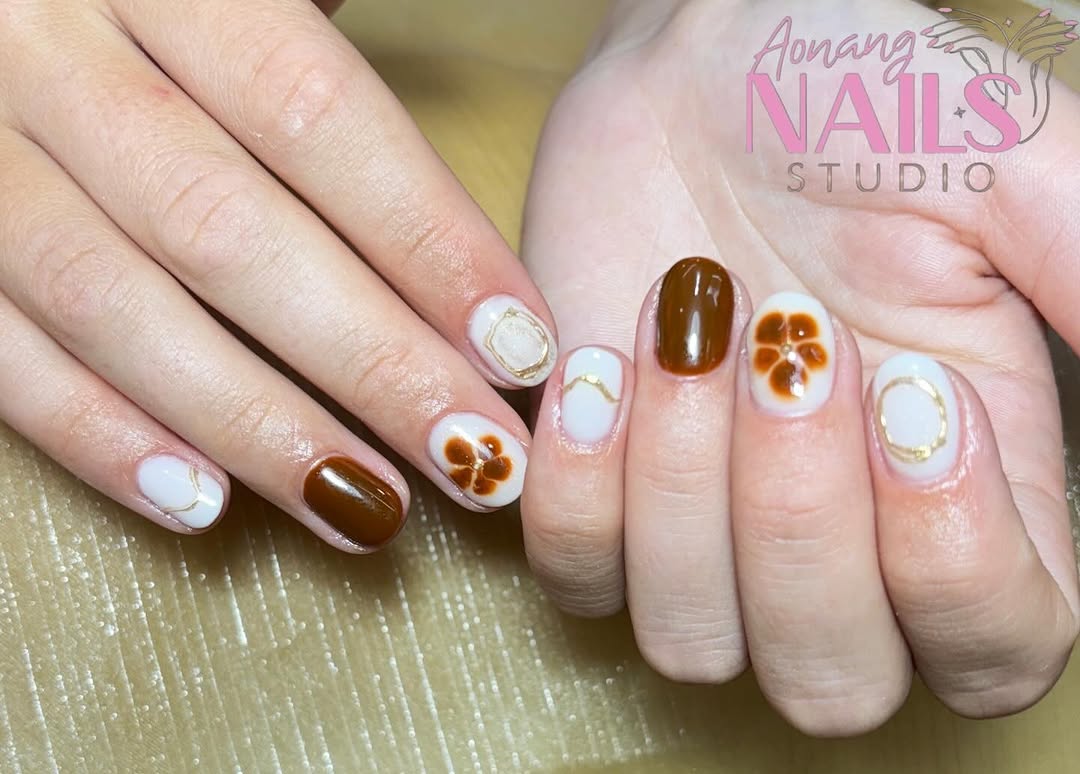 Short oval BIAB set with brown, white and gold nail art